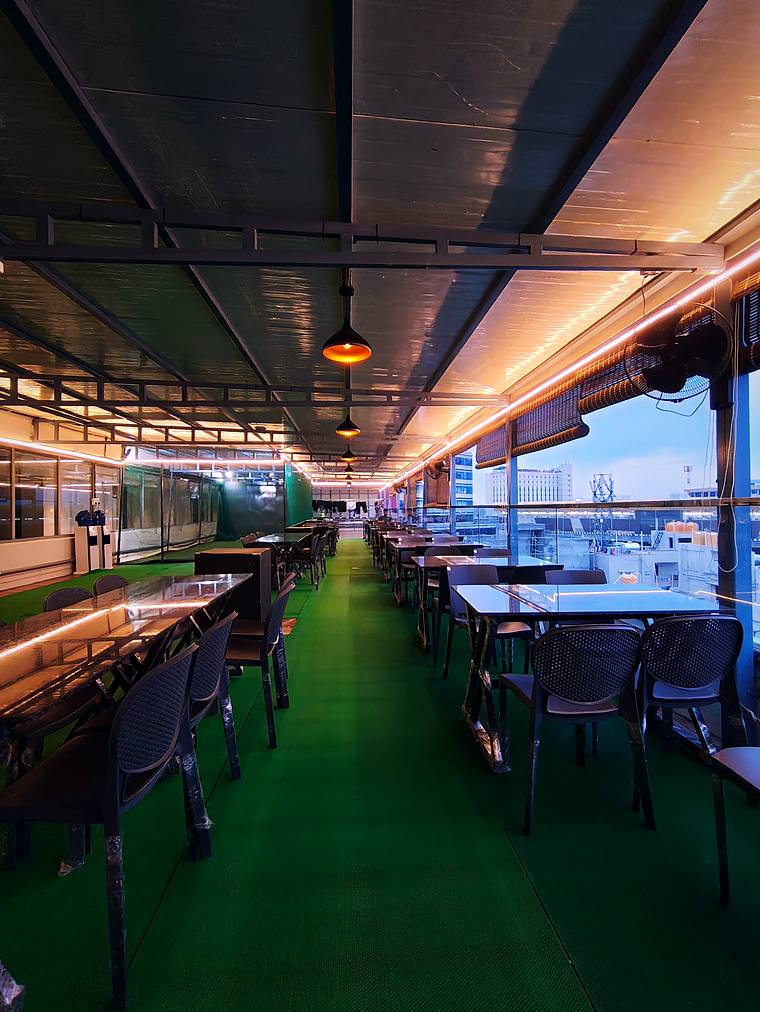 Rooftop terrace dining, enclosed and lit — Vaikuntum Elite Co-Living