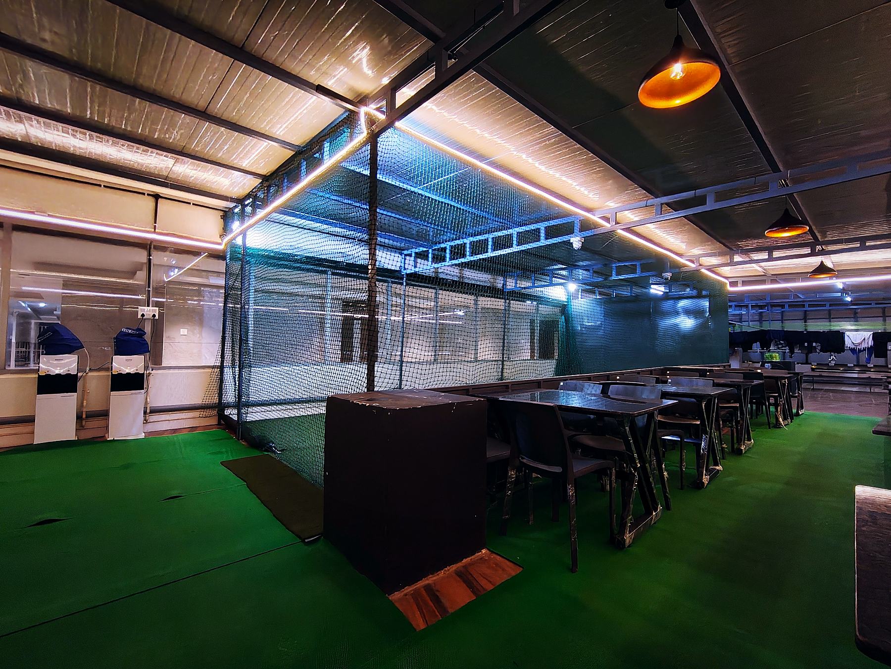 Floodlit rooftop box-cricket arena at night, Vaikuntum Elite Co-Living, Bommanahalli