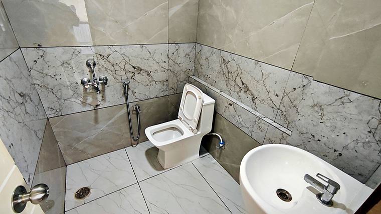 Clean tiled shared bathroom — Vaikuntum Elite Co-Living